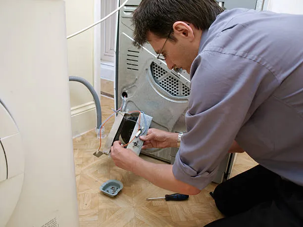 A person fixing dryer in home.