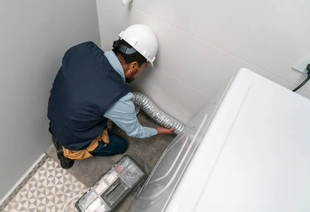 An expert wearing white cap is working on dryer pipe.