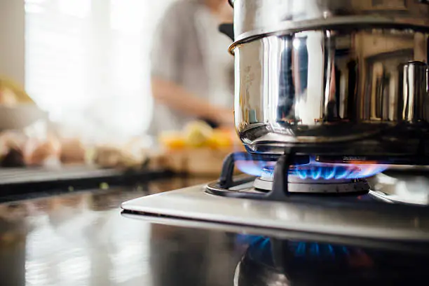 woman cooking meal on gas cooker